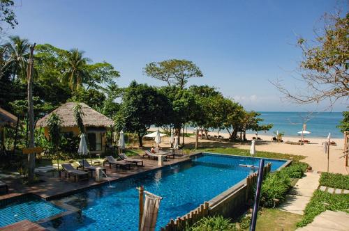 uma piscina ao lado de uma praia com o oceano em LaLaanta Hideaway Resort em Ko Lanta