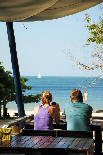 a man and woman sitting on a bench looking at the ocean at LaLaanta Hideaway Resort in Ko Lanta