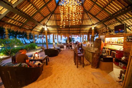 a restaurant with a bar and people sitting at tables at LaLaanta Hideaway Resort in Ko Lanta