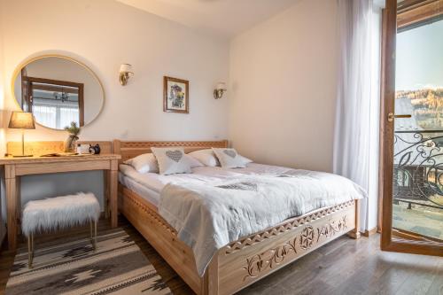 1 dormitorio con cama, mesa y espejo en Willa Kasztan, en Zakopane
