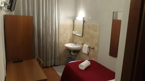 米蘭的住宿－Hotel Tirreno，一间带红色床和水槽的浴室