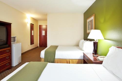 a hotel room with two beds and a television at Holiday Inn Express Harvey-Marrero by IHG in Harvey