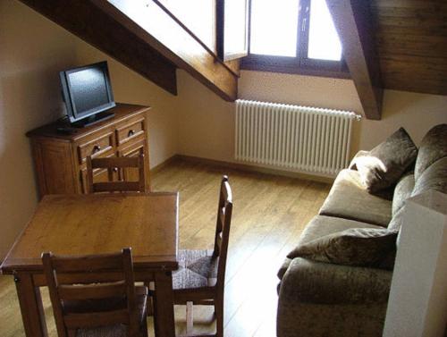 a living room with a couch and a table and a tv at Hotel Areulo in Cerler