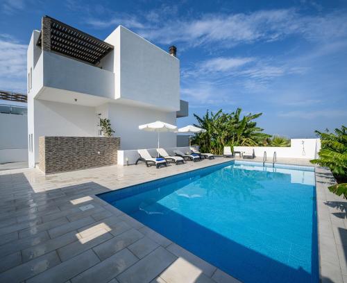 uma villa com uma piscina e uma casa em Asteria Pearl Villa 1 new Jacuzzi em Tigaki