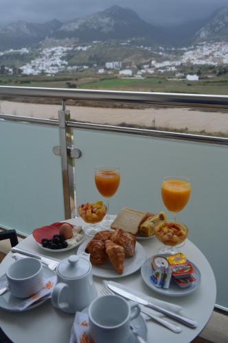 a table with breakfast food and two glasses of orange juice at Prestige Hotel & Spa in Tetouan