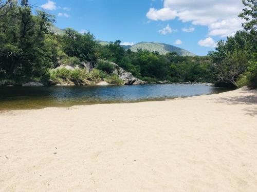piaszczysta plaża obok rzeki z drzewami w obiekcie Lo de Jenny w mieście San Marcos Sierra