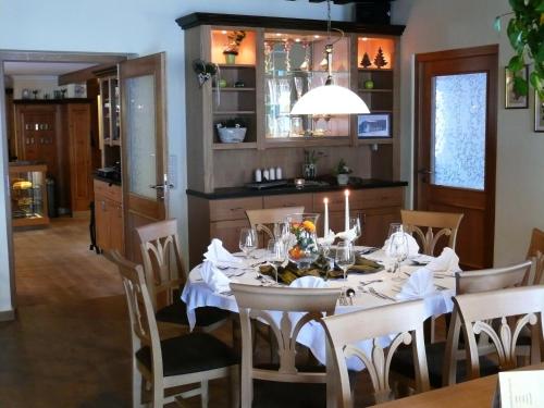 een eetkamer met een tafel met kaarsen erop bij Zur Alten Dampfsäge - Gasthaus-Pension Weber in Lindberg