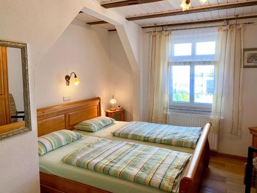 ザスニッツにあるVilla-Rosengarten-Ferienwohnung-Baumhaus-mit-Seeblickのベッドルーム1室(ベッド2台、窓付)