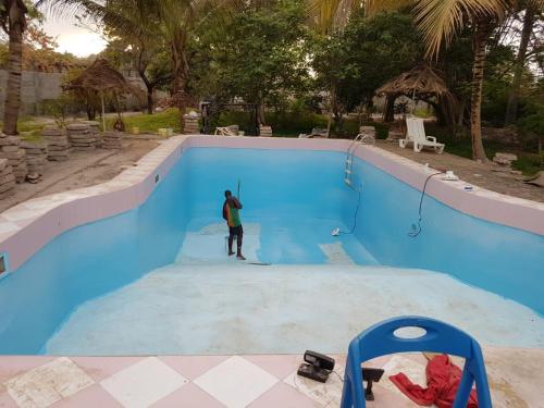 a man standing in the middle of a swimming pool at Villa Amarant - Private Garden with Pool Retreat in Sanyang