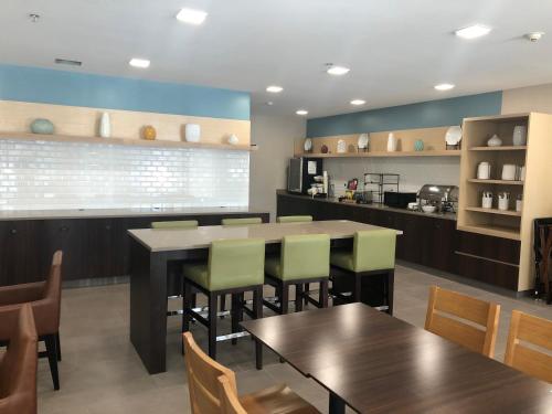 a dining room with tables and chairs and a kitchen at Country Inn & Suites by Radisson, Stone Mountain, GA in Stone Mountain