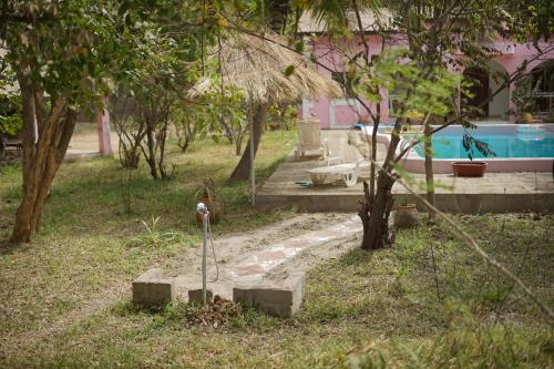 a garden with a parking meter in the grass at Villa Amarant - Private Garden with Pool Retreat in Sanyang