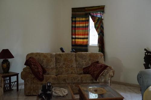a living room with a couch and a window at Villa Amarant - Private Garden with Pool Retreat in Sanyang