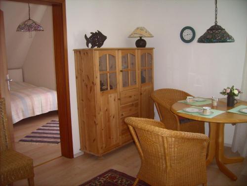 une salle à manger avec une table et une armoire dans l'établissement Haus-Halligblick-Ferienwohnung-Langenness, à Dagebüll