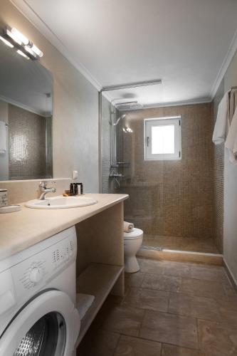 a bathroom with a sink and a washing machine at Villa Spitaki in Makrátika