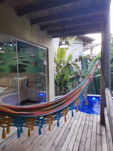 a hammock on a deck next to a pool at Villas do Pratagy in Maceió