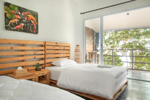 a bedroom with two beds and a large window at Beu Ceubeh Cottage - Family Room in Sabong