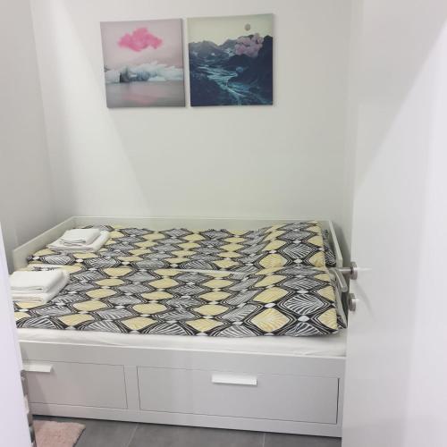 a bed with a black and yellow comforter on it at KoVeL apartmani - Termalna Rivijera in Bogatić