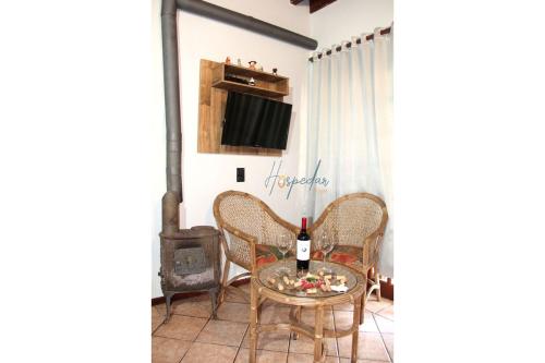 a room with a table with a bottle of wine at Chalés Saint Germain in Florianópolis