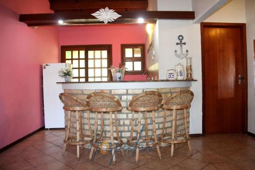 a kitchen with a bar with stools at Chalés Saint Germain in Florianópolis