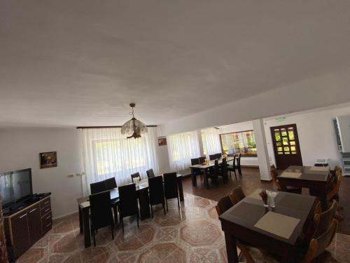 a living room with tables and chairs and a television at Pensiunea din Livada in Bran