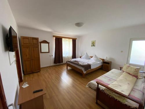a living room with two beds and a couch at Pensiunea din Livada in Bran