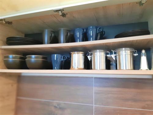 a kitchen shelf with pots and pans on it at Dream Milmari L12 Apartman in Kopaonik