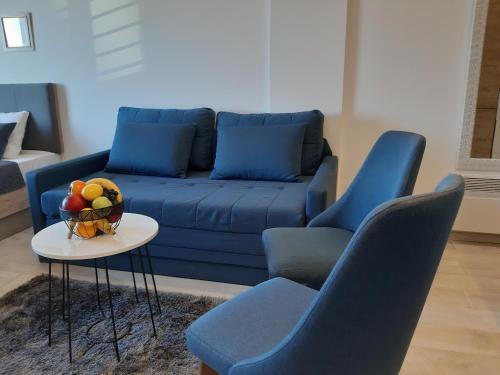 a living room with a blue couch and chairs at Dream Milmari L12 Apartman in Kopaonik