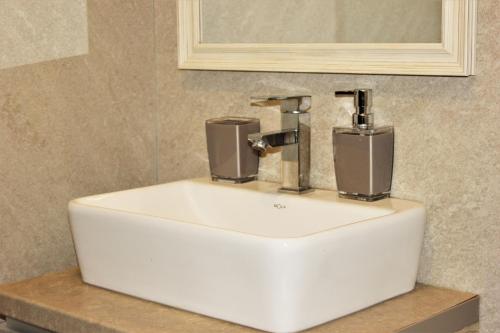 a white sink in a bathroom under a mirror at Dream Milmari L12 Apartman in Kopaonik