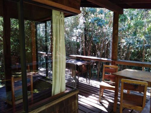 eine abgeschirmte Veranda einer Hütte mit Bäumen in der Unterkunft Cabaña en Río Puelo in Puelo