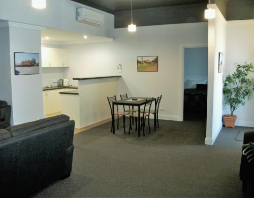 a living room and kitchen with a table and chairs at Daydream Motel and Apartments in Broken Hill