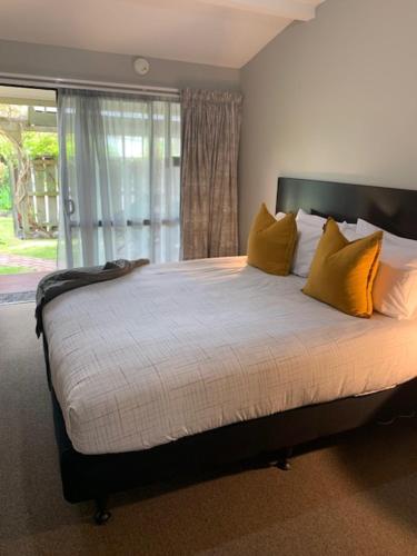 a bedroom with a bed with yellow pillows and a window at Twizel Central Studio Accommodation in Twizel