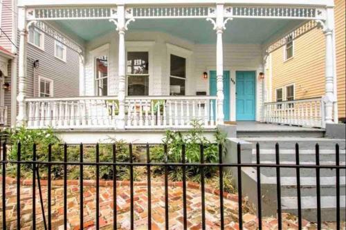 a house with a white porch and a fence at 243 Rutledge in Charleston