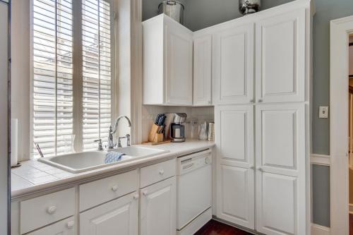 uma cozinha com armários brancos e um lavatório em 125 Church em Charleston