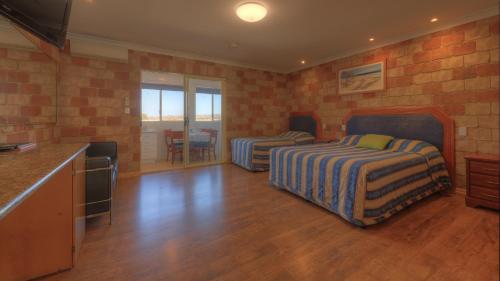 1 dormitorio con 2 camas y cocina con encimera en Golfers Inn, en Tenterfield