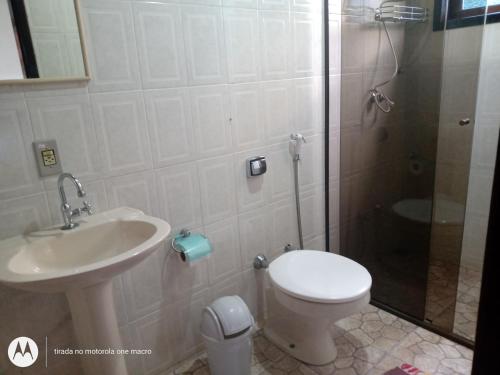 a bathroom with a toilet and a sink and a shower at Pousada Nova Conquista in Penedo