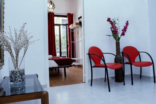 a living room with red chairs and a table at Casa Lemus in Madrid