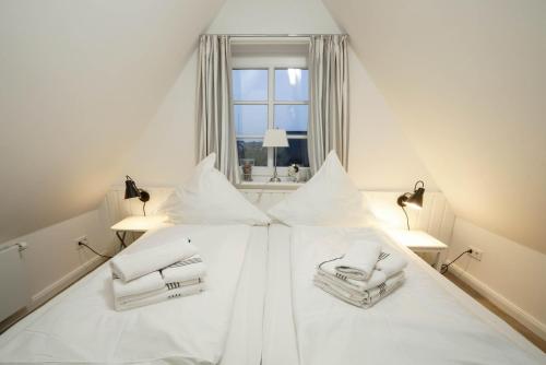 ヴェスターラントにあるApp. Kliffの白い枕と窓が備わる白いベッド