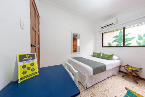 een kleine slaapkamer met een bed en een raam bij Hotel Ayenda Casa Cano 1805 in Cartagena