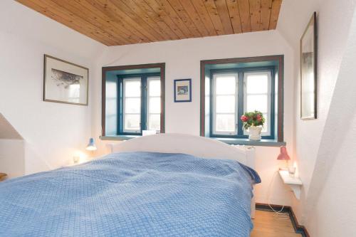 - une chambre avec un lit et 2 fenêtres dans l'établissement Hansen-Hof-Wohnung-2, à Tinnum