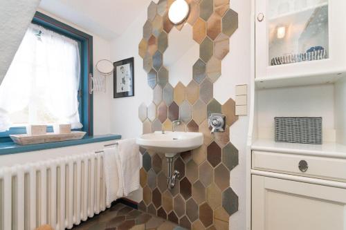 La salle de bains est pourvue d'un lavabo et d'un miroir. dans l'établissement Hansen-Hof-Wohnung-2, à Tinnum