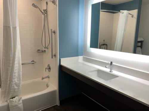 a bathroom with a sink and a tub and a mirror at Candlewood Suites Pecos by IHG in Pecos