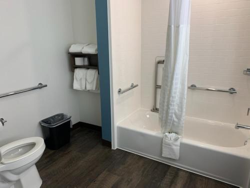 a bathroom with a toilet and a tub and a shower at Candlewood Suites Pecos by IHG in Pecos