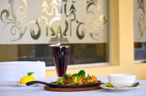 a plate of food on a table with a drink at Hotel y Restaurante Castillo de los Altos in Quetzaltenango