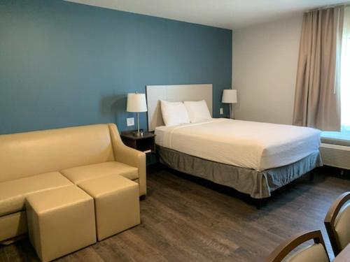 a hotel room with a bed and a couch at Candlewood Suites Pecos by IHG in Pecos