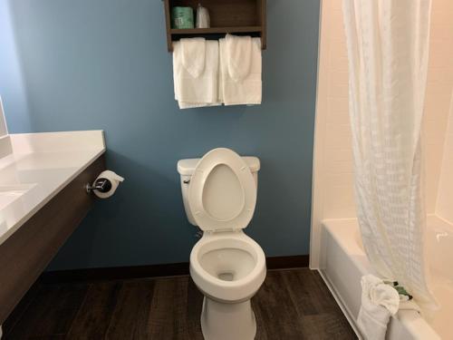 a bathroom with a toilet and a sink and a tub at Candlewood Suites Pecos by IHG in Pecos