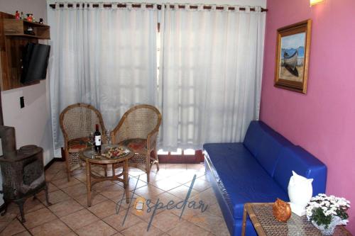 a living room with a blue couch and a table at Chalés Saint Germain in Florianópolis