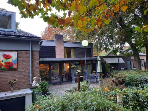 ein Haus mit einer Terrasse davor in der Unterkunft Villa Berk en Heide in Rosmalen