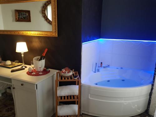 a bathroom with a tub with a table and a chair at B&B I Puritani in Catania