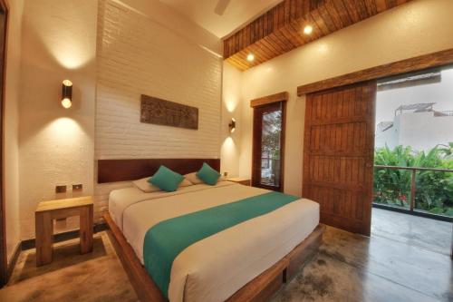 a bedroom with a large bed with green pillows at Echoland Boutique Bed And Breakfast in Canggu