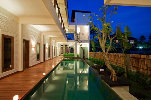 an infinity pool in a villa at night at Echoland Boutique Bed And Breakfast in Canggu